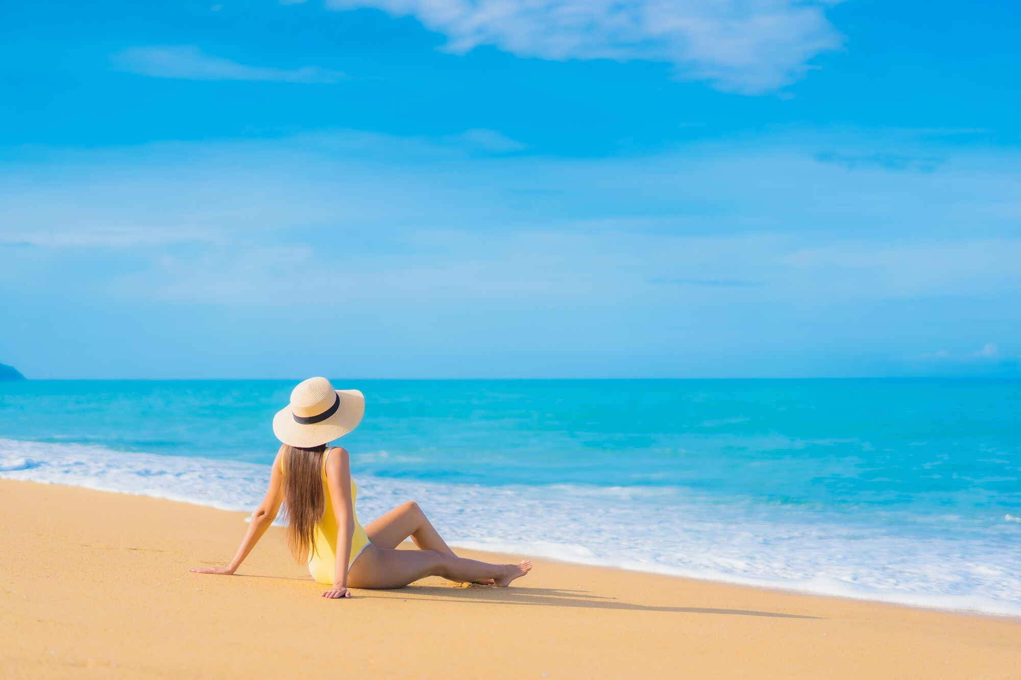 Relaxing traveler with hat on beach