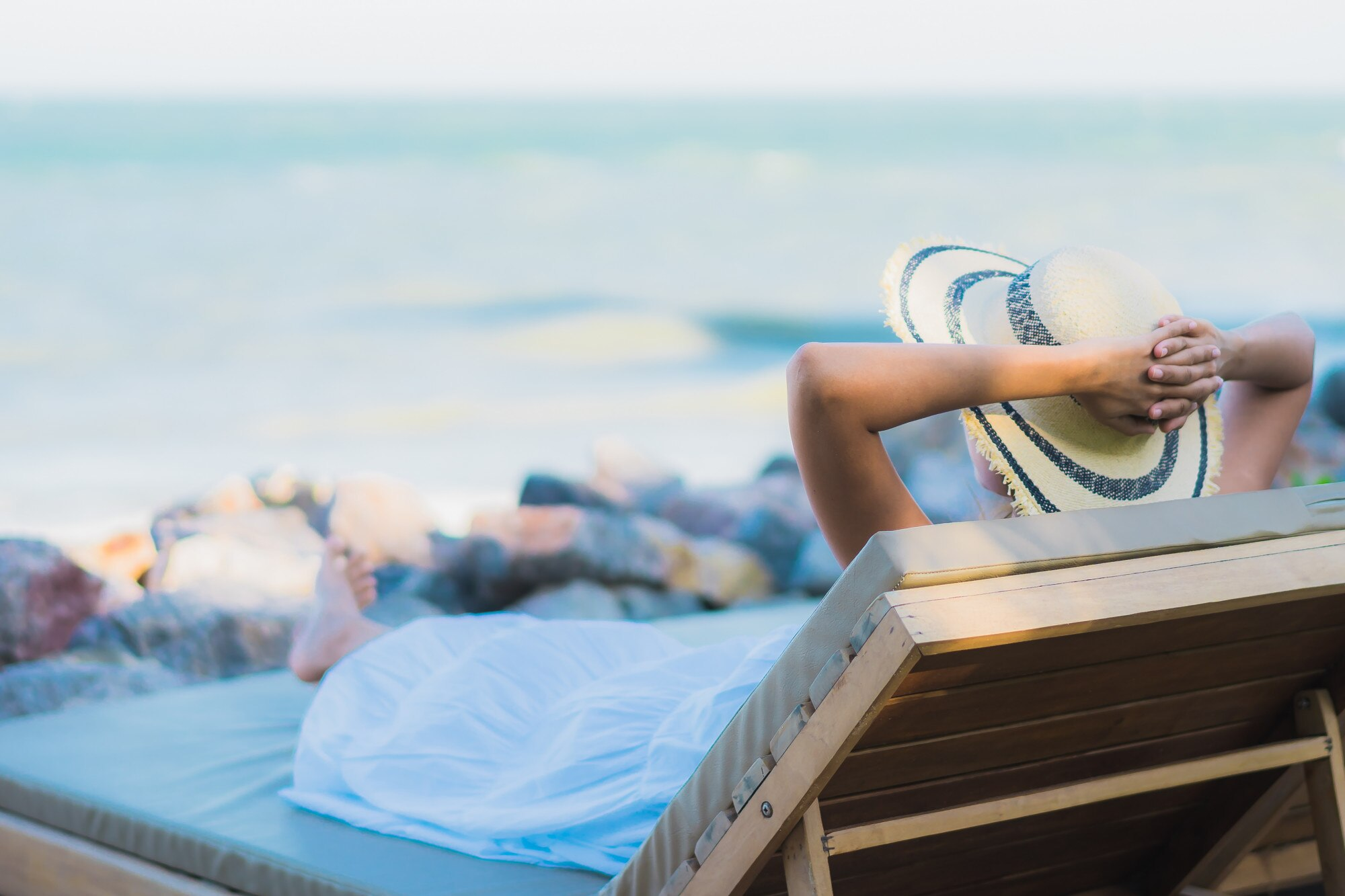 Relaxing traveler with hat on beach