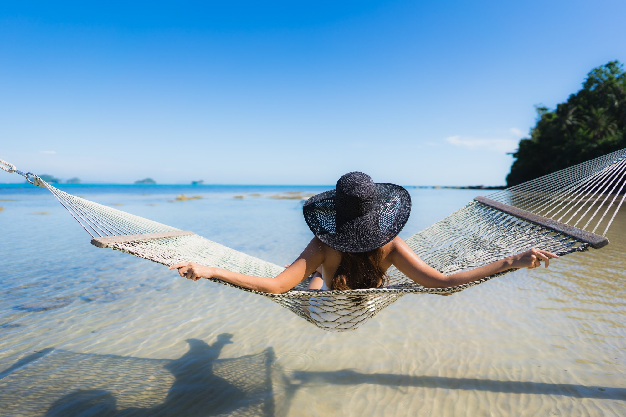 Relaxing traveler with hat on beach